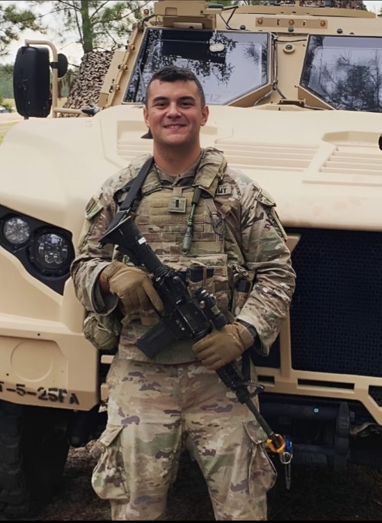 Danny in uniform in front of a tactical vehicle