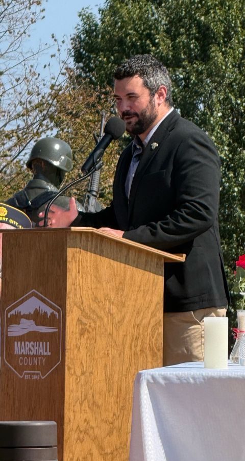 Danny speaking at a podium at the Marshall County POW/MIA Recognition Day ceremony