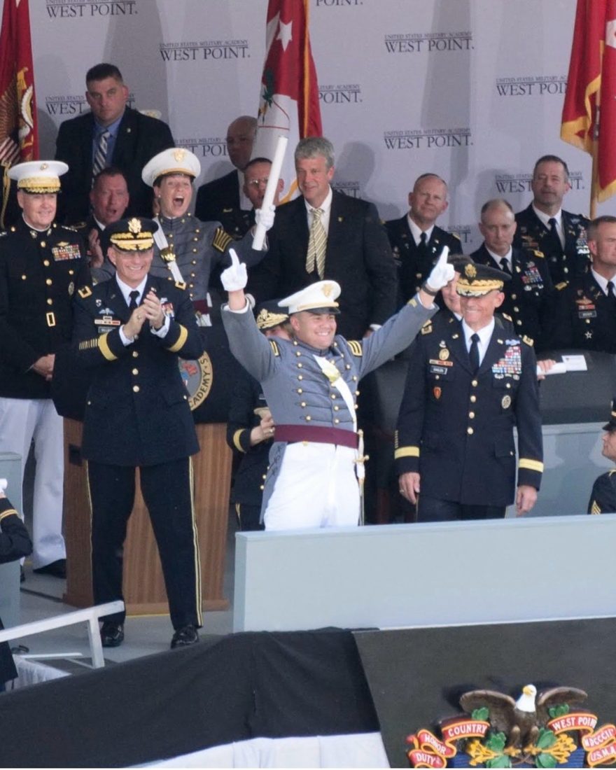 Danny celebrating on the West Point graduation stage as generals applaud